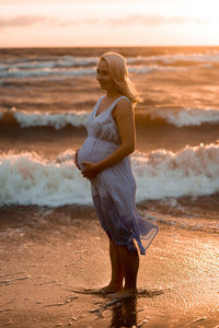 Pregnant woman standing on beach