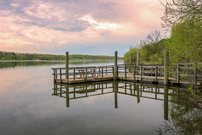 Scenic view of lake against cloudy sky during sunset