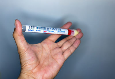 Close-up of woman holding hands over white background