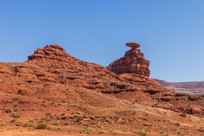 Rock formations on mountain against clear blue sky