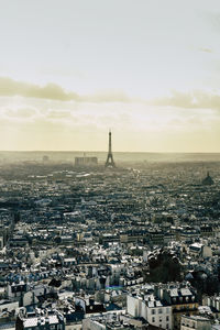 Aerial view of city buildings against cloudy sky