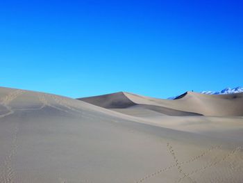 Sand dunes in desert against clear blue sky