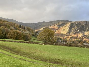 View through the valley in the lake district with the autumn sun shining on the hillside