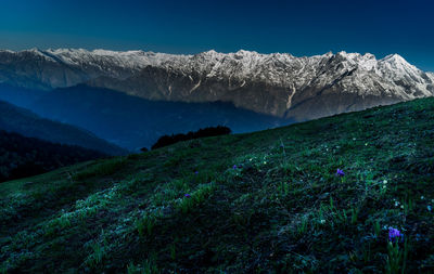 Scenic view of snowcapped mountains against clear blue sky