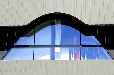 Low angle view of glass building against sky