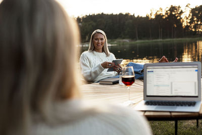 Smiling woman sitting at lake