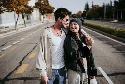 Portrait of friends standing on road in city