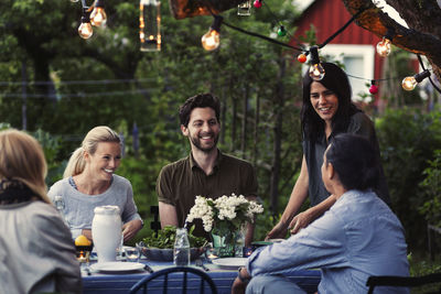 Happy friends enjoying dinner party at yard