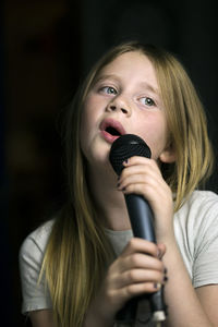 Girl holding microphone and singing