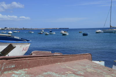 Boats moored on sea against sky