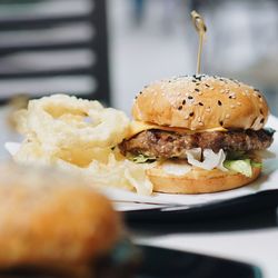 Hamburger with fried onion rings served on table