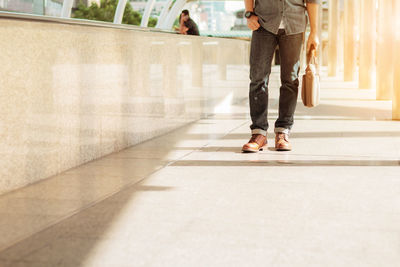 Low section of people walking on floor in city