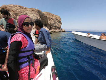 Smiling woman sitting on boat in sea