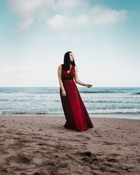 Woman standing on beach against sky