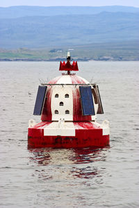 Red ship in sea against sky