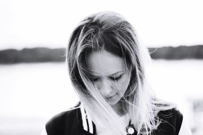 Close-up of young woman against lake