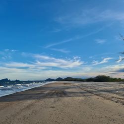 Scenic view of beach against blue sky