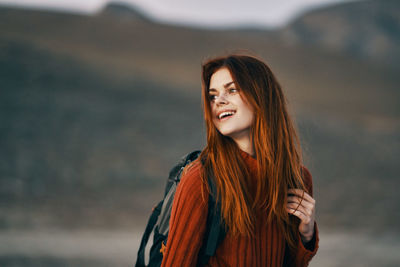 Portrait of smiling young woman standing outdoors