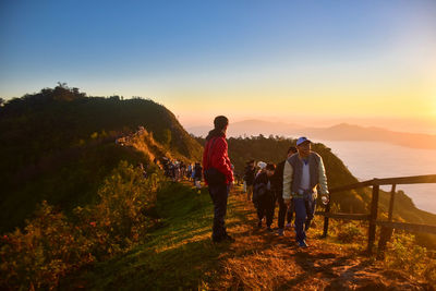 People standing on ridge during sunset