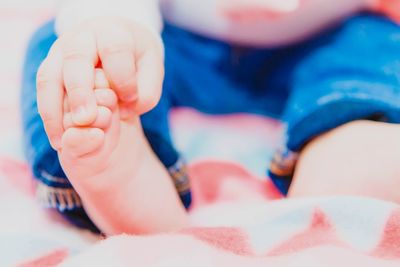 Close-up of baby lying on bed