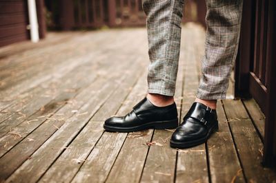 Low section of man standing on boardwalk