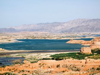 Scenic view of sea and mountains against clear sky