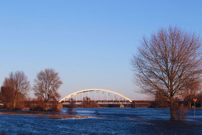 Bridge over river against clear blue sky