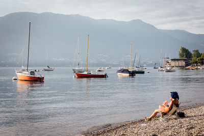 Woman looking at view while sitting on chair at beach