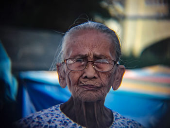 Close-up portrait of senior woman wearing eyeglasses outdoors