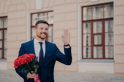 Full length of a man holding red rose