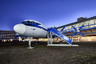 Airplane on airport runway against clear blue sky