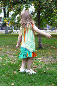 Little girl is walking in park, back view. walking in park in indian summer. farewell to summer.