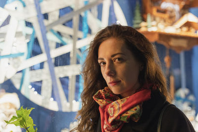 Portrait of woman standing against illuminated lights