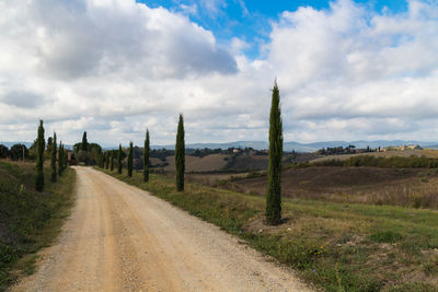 Road amidst field against sky