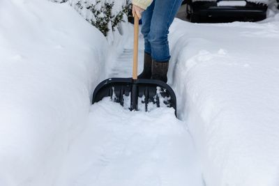 Low section of man skiing on snow covered field