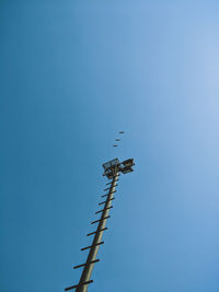 Low angle view of airshow against clear blue sky