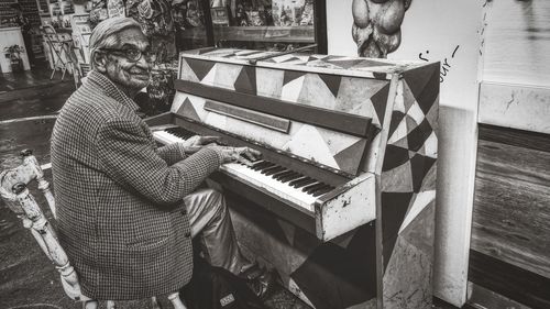 Side view of man playing piano