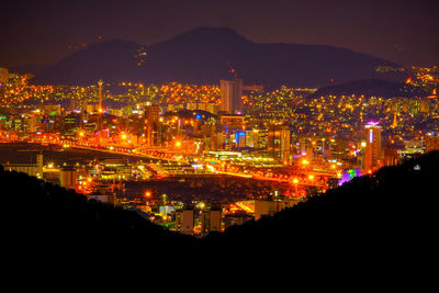 Illuminated cityscape against sky at night