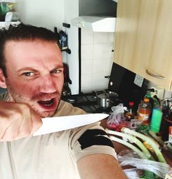 Close-up portrait of senior man in kitchen