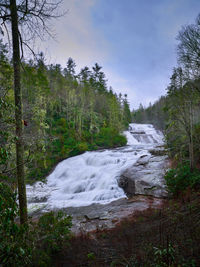 Scenic view of waterfall against sky