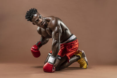 Shirtless boxer on brown background