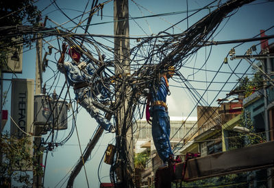 Low angle view of man working against clear sky