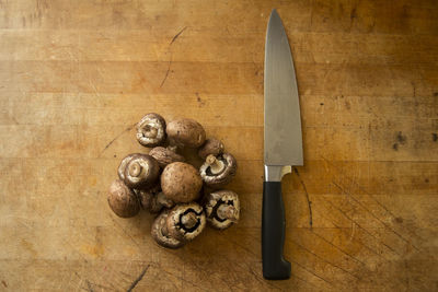 Close-up of mushrooms and knife on wood