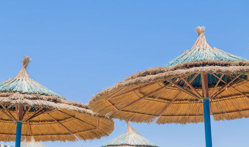 Low angle view of traditional windmill against clear blue sky