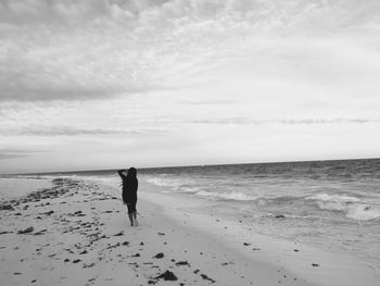 Rear view of man walking on beach