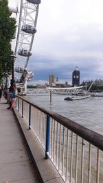 Bridge over river against sky in city