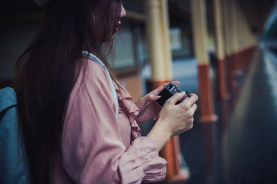 Midsection of woman using mobile phone