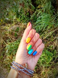 Close-up of woman hand holding plant on field