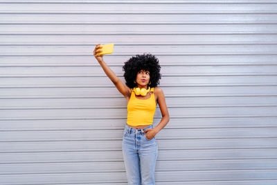 Rear view of woman standing against wall