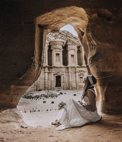 Woman sitting on old historical building